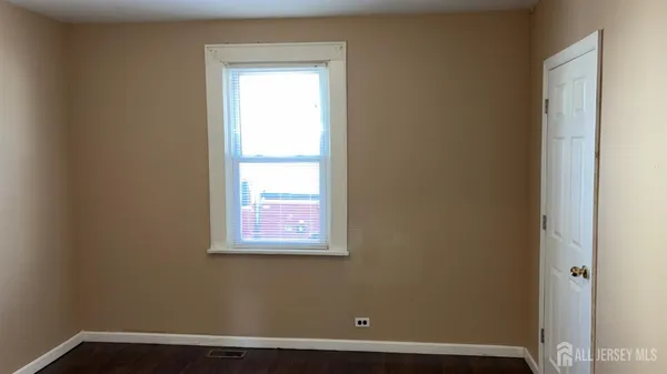 a view of a small space with wooden floor and a window
