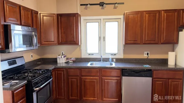 a kitchen with granite countertop wooden cabinets and a stove top oven
