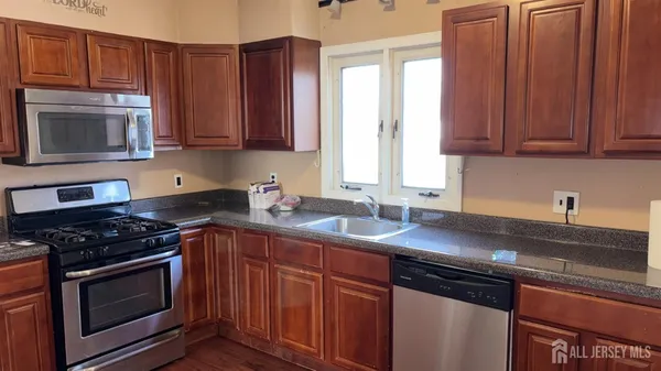 a kitchen with granite countertop a sink stove and cabinets