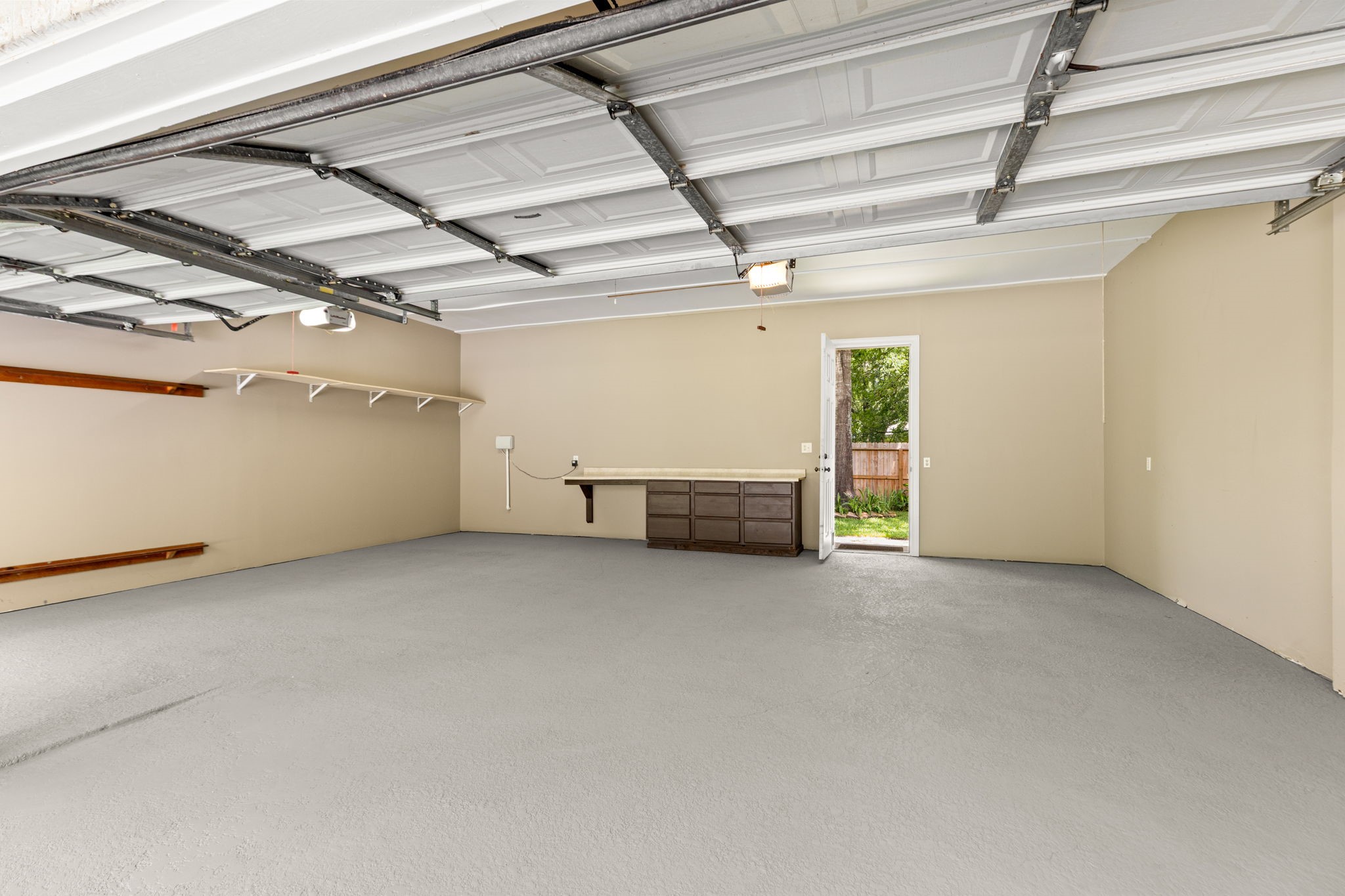 6610 Radley Drive Spring, TX 77379 - Photo 44 of 50 3 car oversized garage w/ door leading to back yard & storage shed. Walls & floors freshly painted. Porte-cochere flooring was just resurfaced. Total covered parking = 6 vehicles!!!