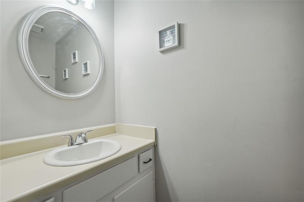 6420 Marbut Road Lithonia, GA 30058 - Photo 14 of 29 a bathroom with a granite countertop sink and a mirror