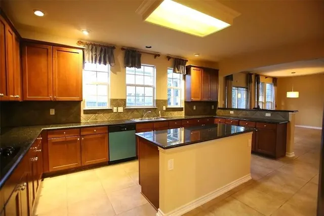 a kitchen with kitchen island granite countertop a sink counter top space and stainless steel appliances