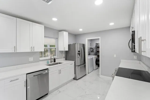 a kitchen with refrigerator and cabinets