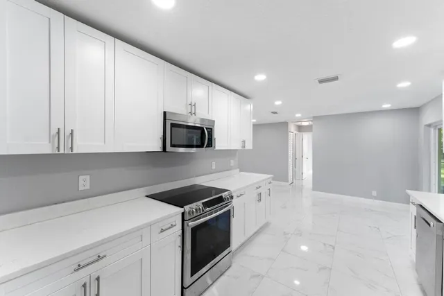 a kitchen with stainless steel appliances granite countertop a sink and a stove