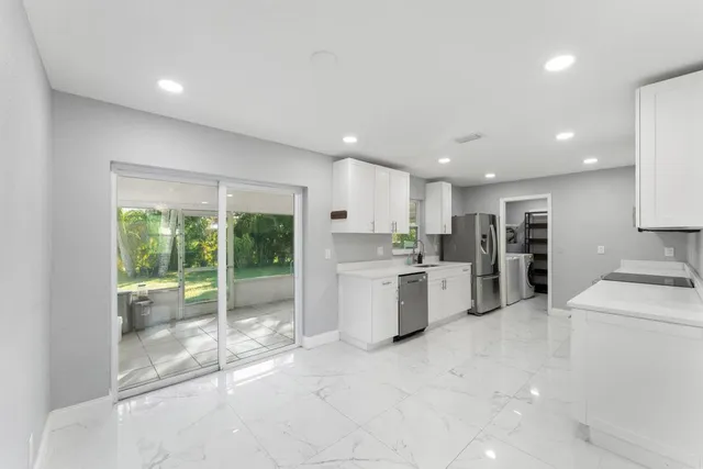 a large kitchen with a large window and stainless steel appliances