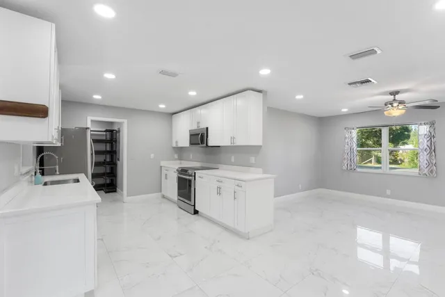 a kitchen with stainless steel appliances kitchen island granite countertop a sink and cabinets
