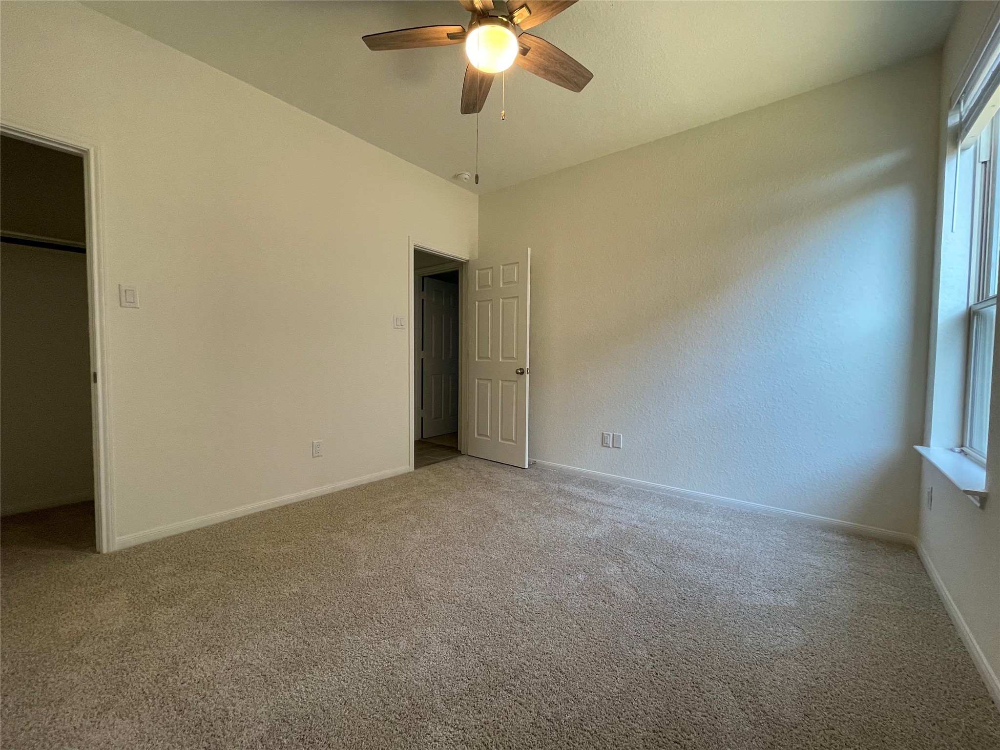 4118 Guild Meadows Drive Houston, TX 77084 - Photo 16 of 35 an empty room with a chandelier fan and windows