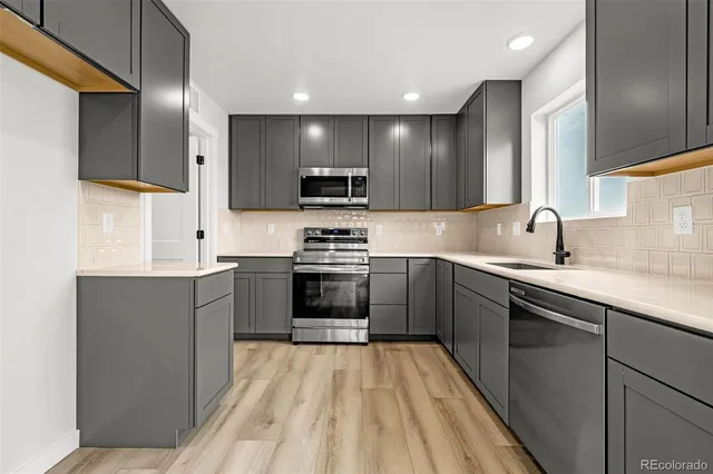 a kitchen with a sink stove and refrigerator
