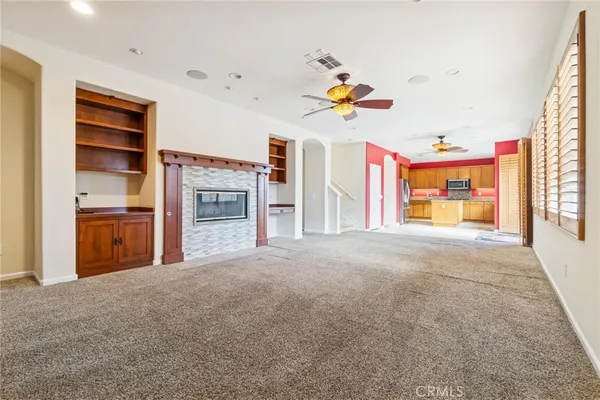 an empty room with a window and a ceiling fan
