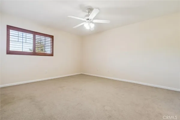 a view of an empty room with a fireplace and a window