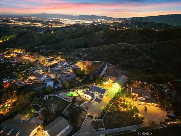 an aerial view of residential houses with outdoor space and trees