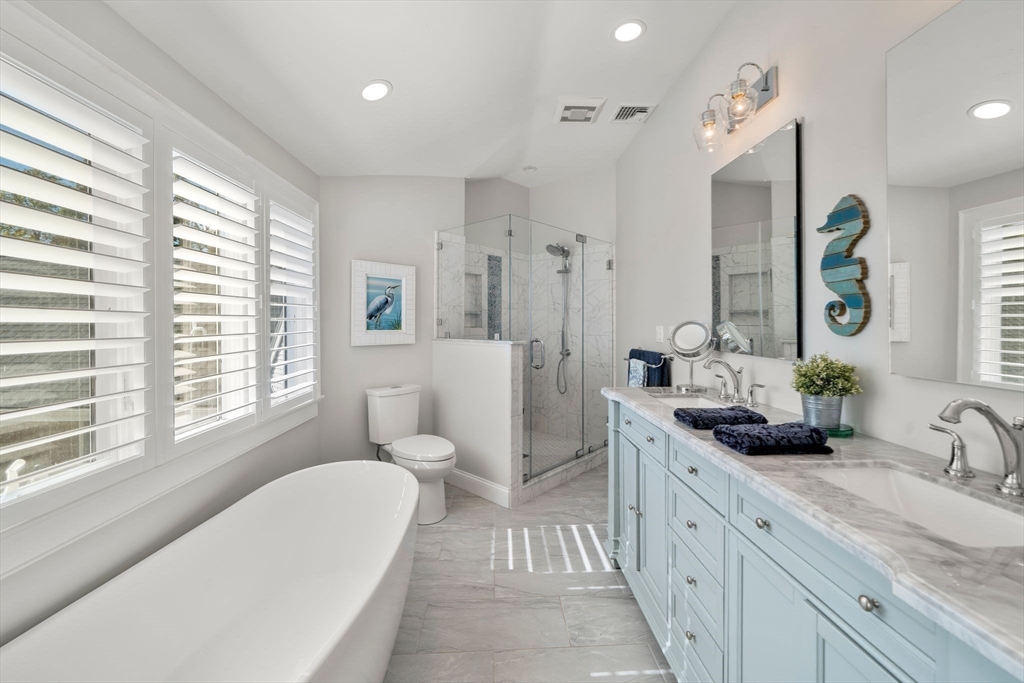 122 Clifford Road Plymouth, MA 02360 - Photo 26 of 38 a spacious bathroom with a double vanity sink a large mirror a bathtub and window