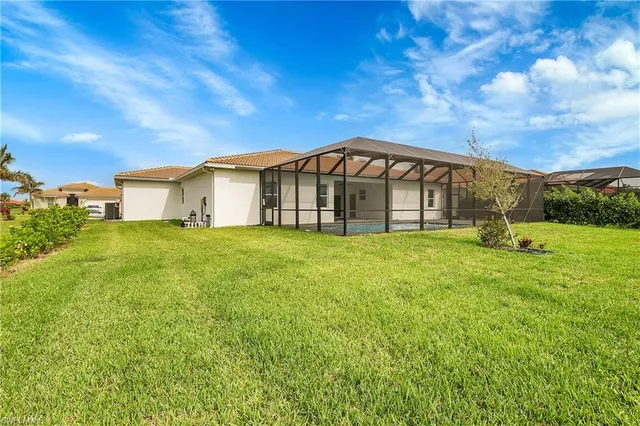 a view of a big house with a big yard and large trees