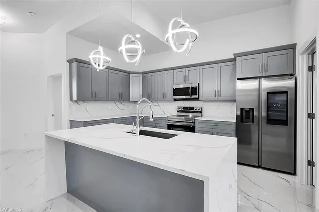 a kitchen with cabinets a sink and stainless steel appliances