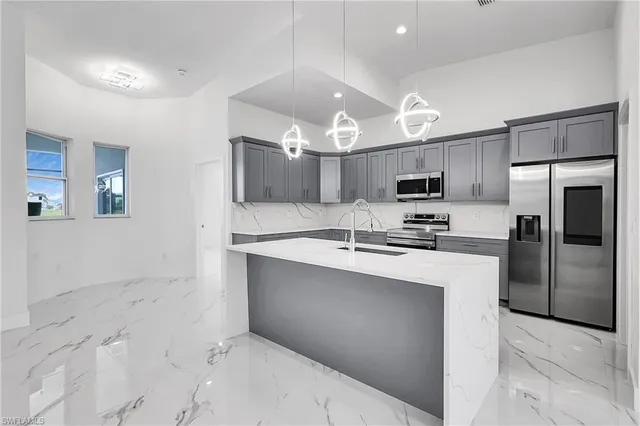 a kitchen with kitchen island a sink stainless steel appliances and cabinets