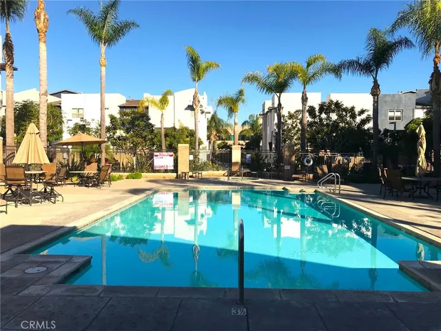 a view of a swimming pool with a lawn chairs under an umbrella