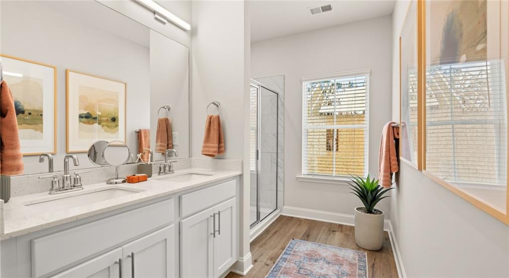 100 Rosemoore Drive Covington, GA 30014 - Photo 12 of 41 a bathroom with a double vanity sink a potted plant and a mirror