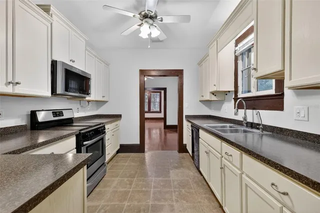 a large kitchen with stainless steel appliances granite countertop a sink and a stove