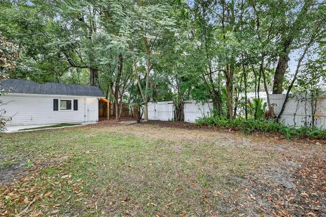 a backyard of a house with large trees and entertaining space
