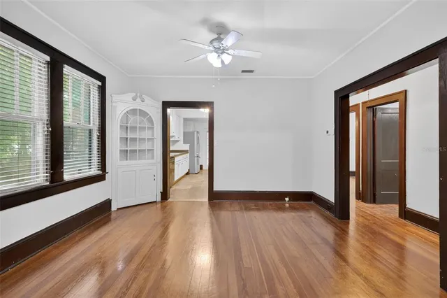a view of an empty room with window and wooden floor