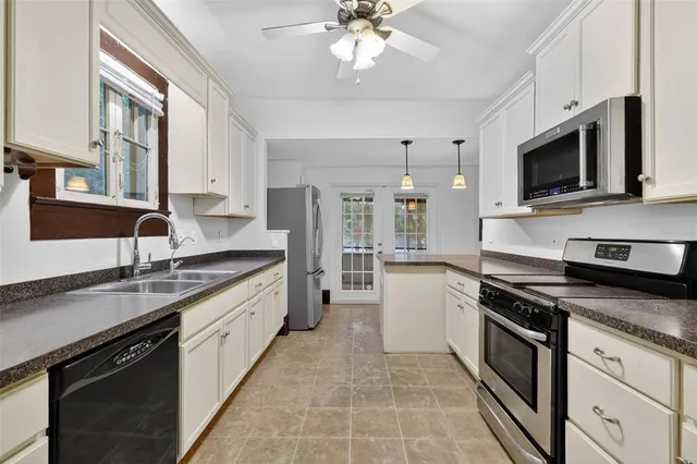 a kitchen with stainless steel appliances granite countertop a sink dishwasher stove and white cabinets