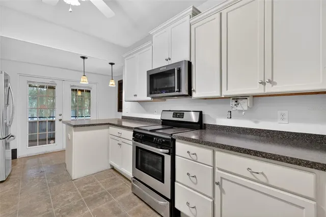 a kitchen with granite countertop white cabinets and white appliances
