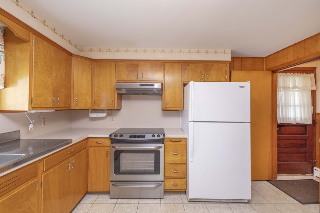 1850 Rodman Street Fall River, MA 02721 - Photo 12 of 42 a kitchen with a refrigerator a stove a sink dishwasher and cabinets with wooden floor