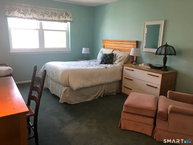 a bedroom with a bed chair and window