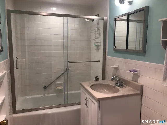 a bathroom with a sink and mirror with bathtub