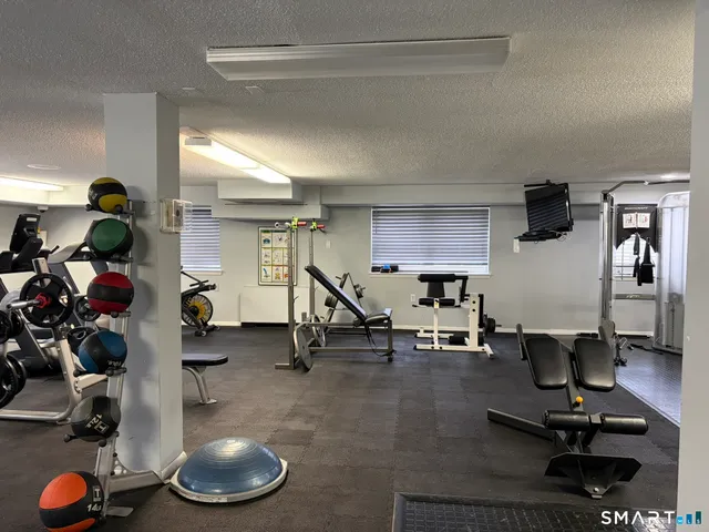 a living room with gym equipment and a wooden floor
