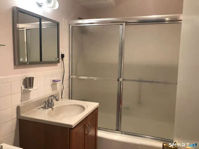 a bathroom with a sink mirror and shower