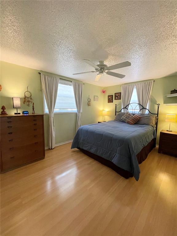 6944 Larchmont Avenue New Port Richey, FL 34653 - Photo 11 of 28 a bedroom with a bed and a night stand