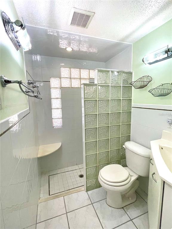 6944 Larchmont Avenue New Port Richey, FL 34653 - Photo 13 of 28 a bathroom with a toilet a sink and shower