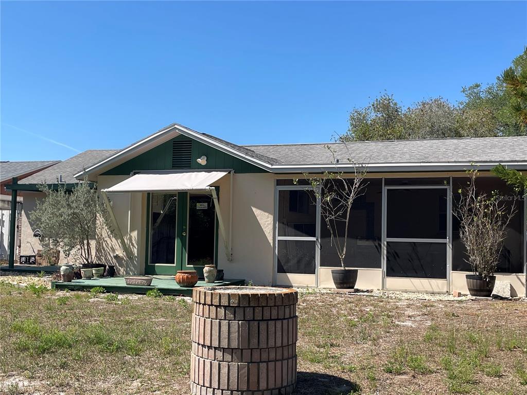 6944 Larchmont Avenue New Port Richey, FL 34653 - Photo 26 of 28 a view of a house with backyard porch and sitting area