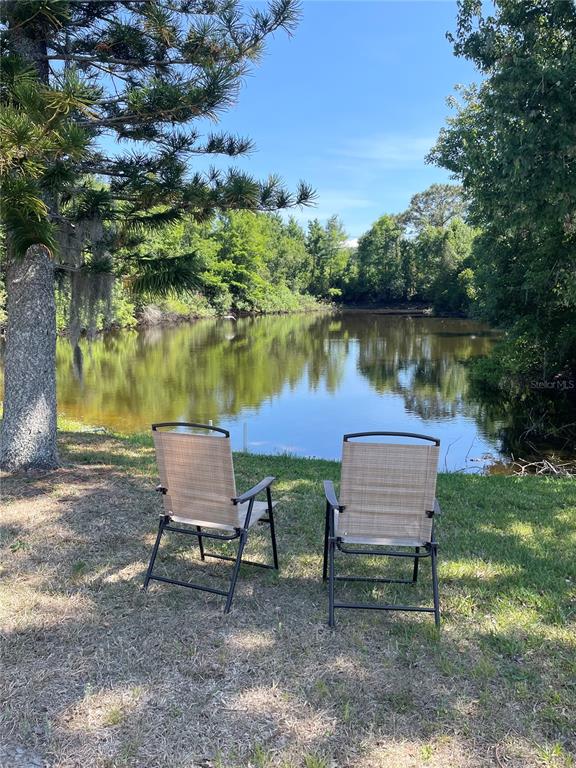 6944 Larchmont Avenue New Port Richey, FL 34653 - Photo 27 of 28 a view of a lake with a bench and lake view