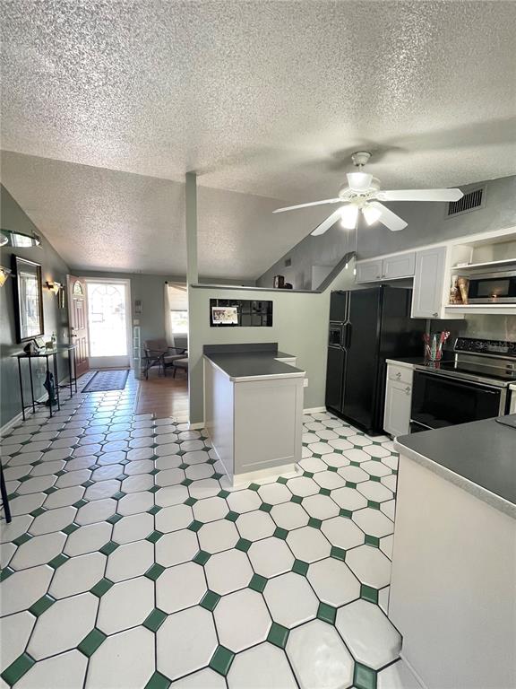 6944 Larchmont Avenue New Port Richey, FL 34653 - Photo 6 of 28 a kitchen with stainless steel appliances a sink a stove a microwave a dining table and chairs