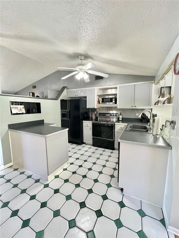 6944 Larchmont Avenue New Port Richey, FL 34653 - Photo 7 of 28 a kitchen with stainless steel appliances a stove a sink a microwave a counter top space and cabinets