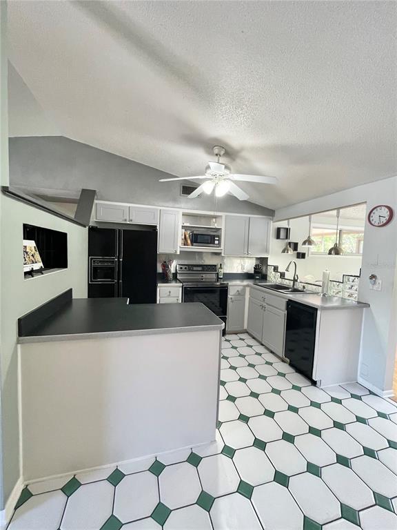 6944 Larchmont Avenue New Port Richey, FL 34653 - Photo 8 of 28 a kitchen with stainless steel appliances kitchen island granite countertop a sink and cabinets