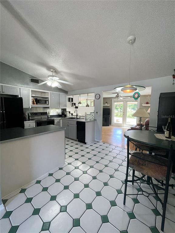 6944 Larchmont Avenue New Port Richey, FL 34653 - Photo 9 of 28 a kitchen with stainless steel appliances a stove a sink a microwave a refrigerator and cabinets