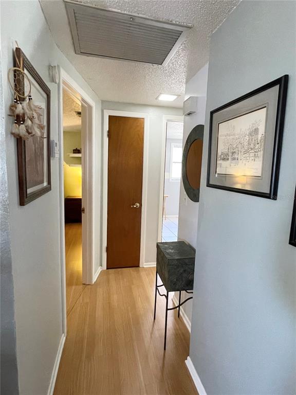6944 Larchmont Avenue New Port Richey, FL 34653 - Photo 10 of 28 a view of a hallway with wooden floor and furniture