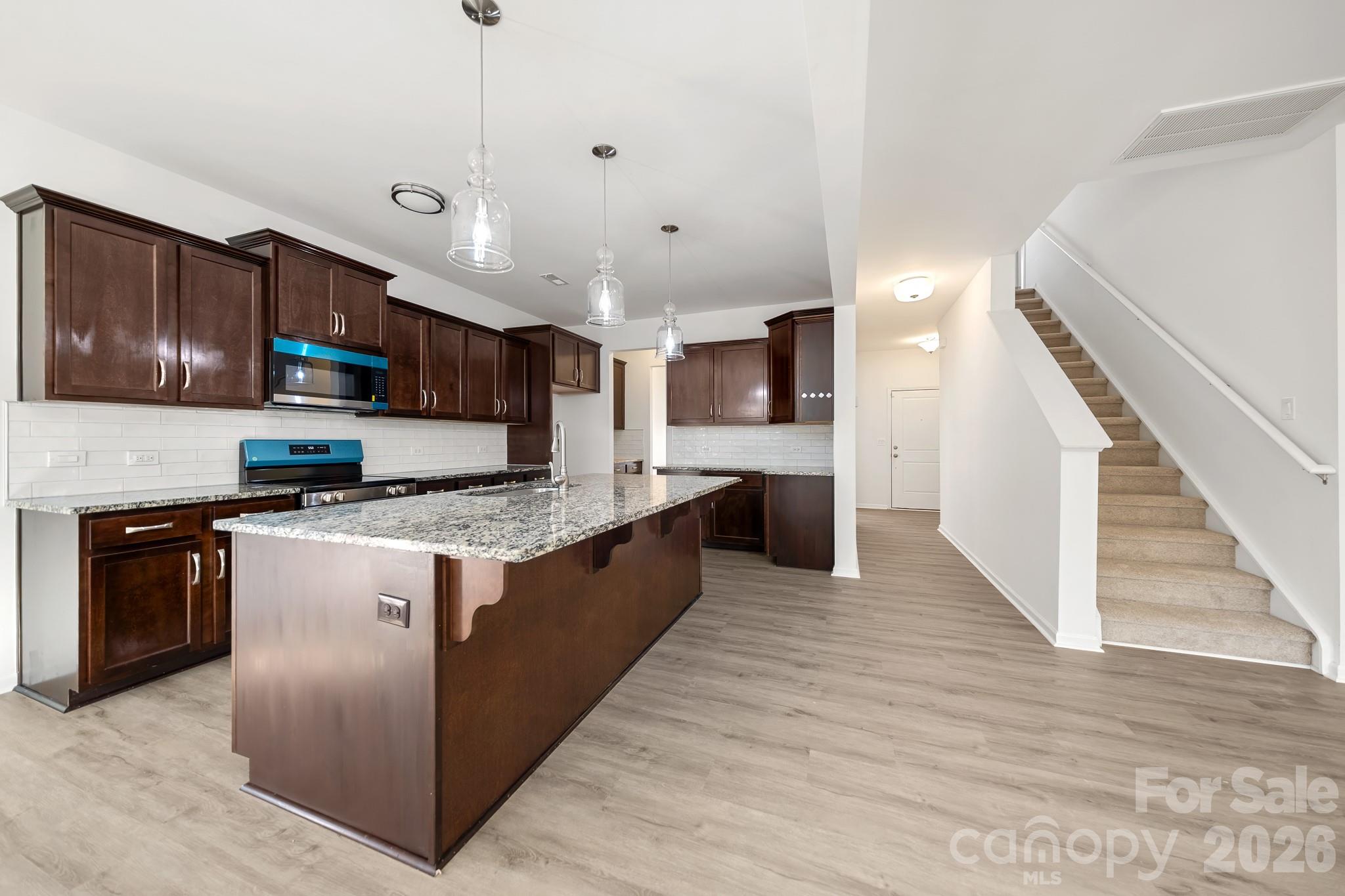 2838 Kinloch Court Clover, SC 29710 - Photo 16 of 42 a large kitchen with stainless steel appliances granite countertop a stove a sink dishwasher a microwave oven and a refrigerator