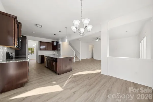 an empty room with wooden floor ceiling fan and windows