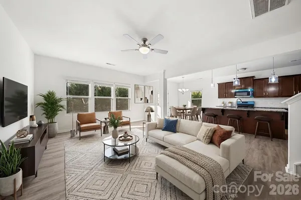 a view of a dining room with furniture a chandelier and wooden floor
