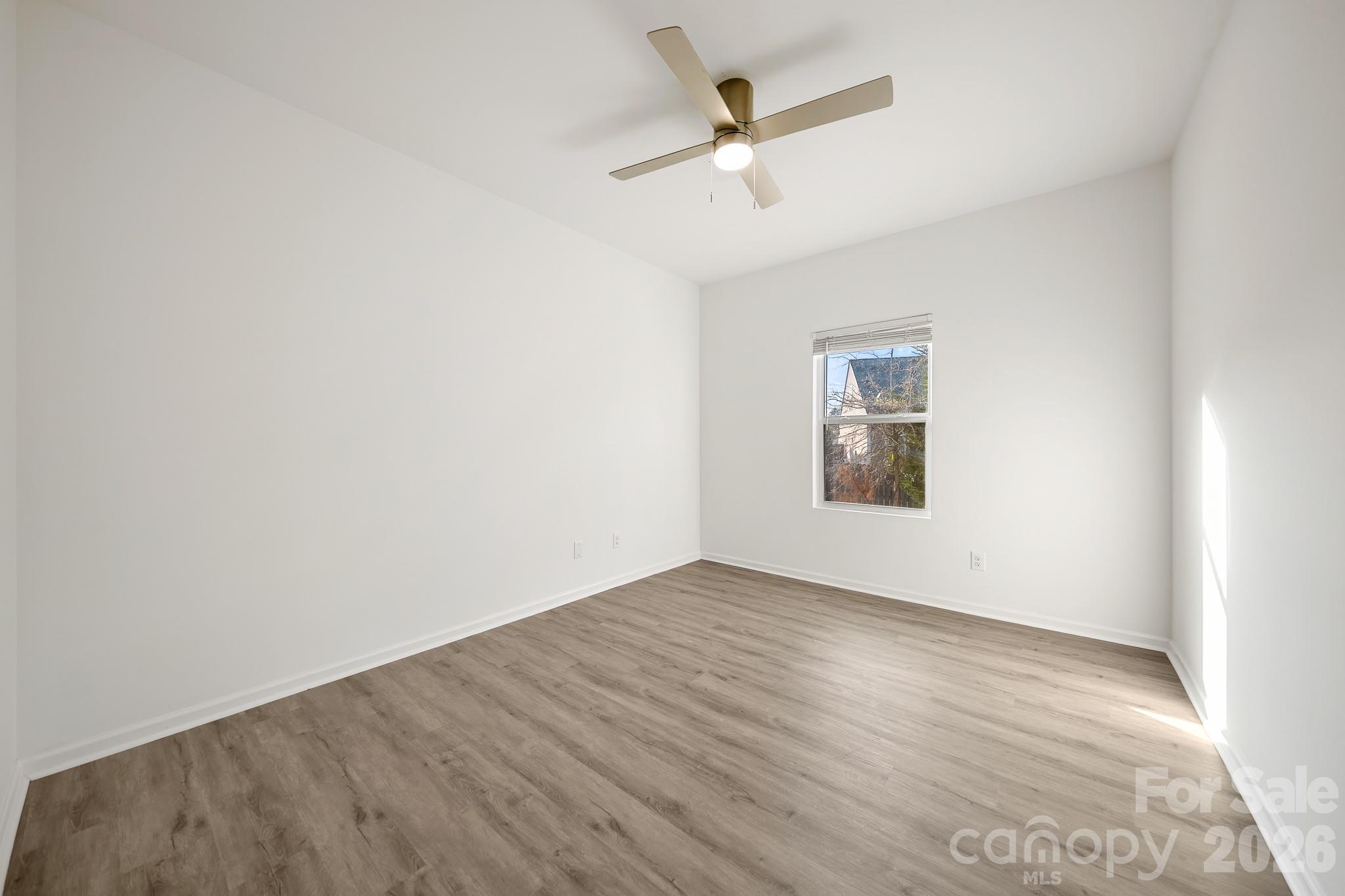 2838 Kinloch Court Clover, SC 29710 - Photo 36 of 42 an empty room with wooden floor ceiling fan and windows