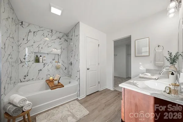 a spacious bathroom with double vanity sinks a large mirror and a bathtub