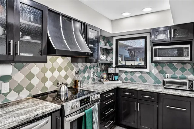 a kitchen with granite countertop a sink stove and cabinets