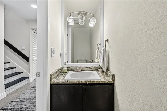 a bathroom with a granite countertop sink and a mirror