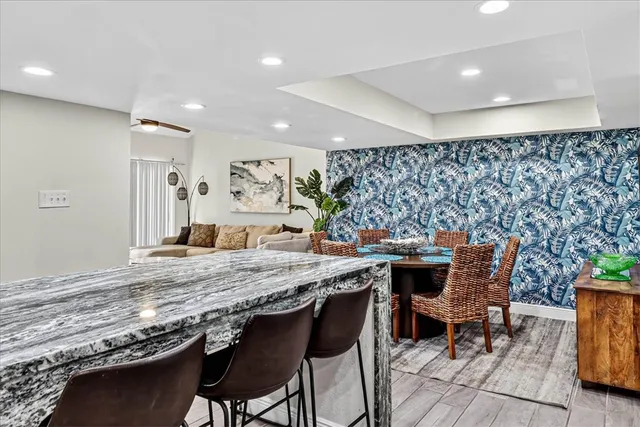 a dining hall with stainless steel appliances granite countertop a table and chairs