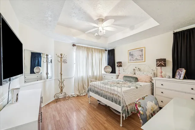 a bedroom with a bed a flat screen tv and a chandelier