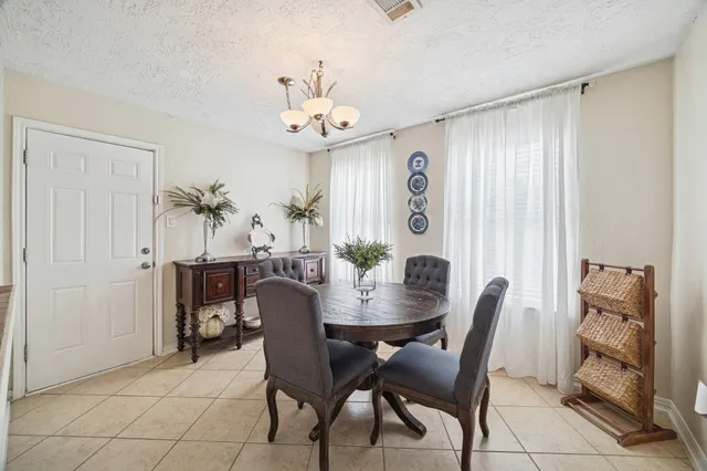 a view of a dining room with furniture and chandelier